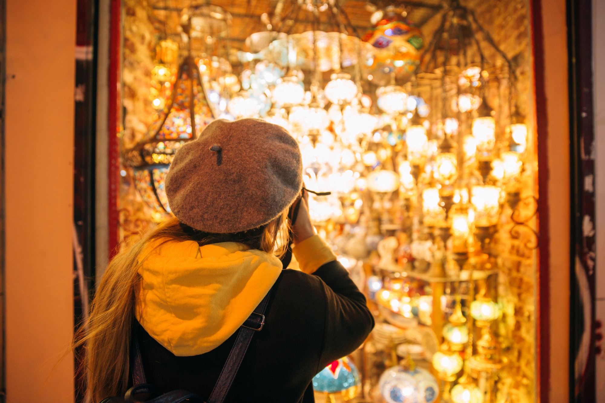 Turkey. Istanbul. Woman tourist photographs shop of lanterns and chandeliers, ethnicity